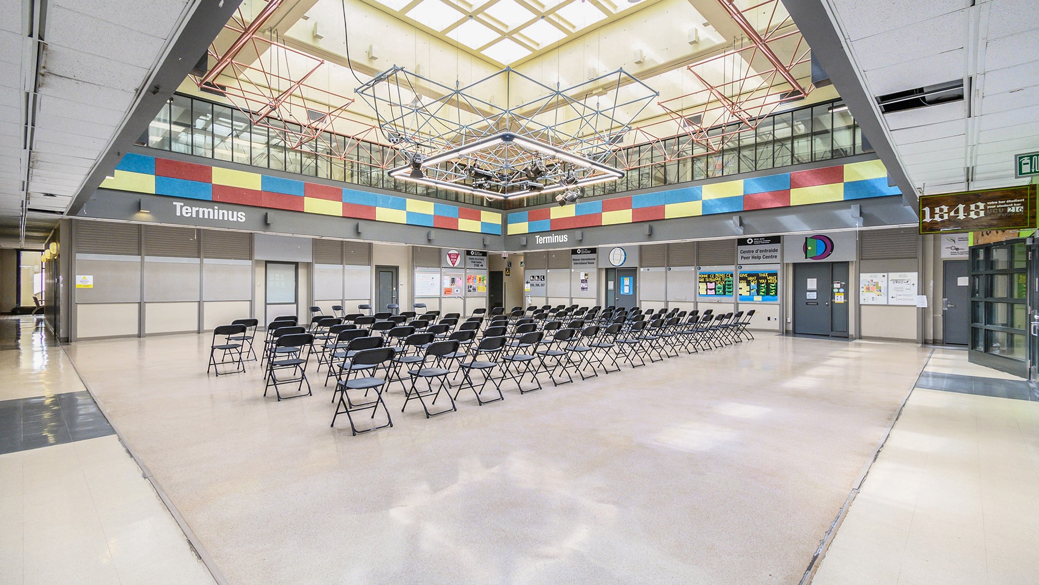 Terminus space with empty chairs set up, from back of room.