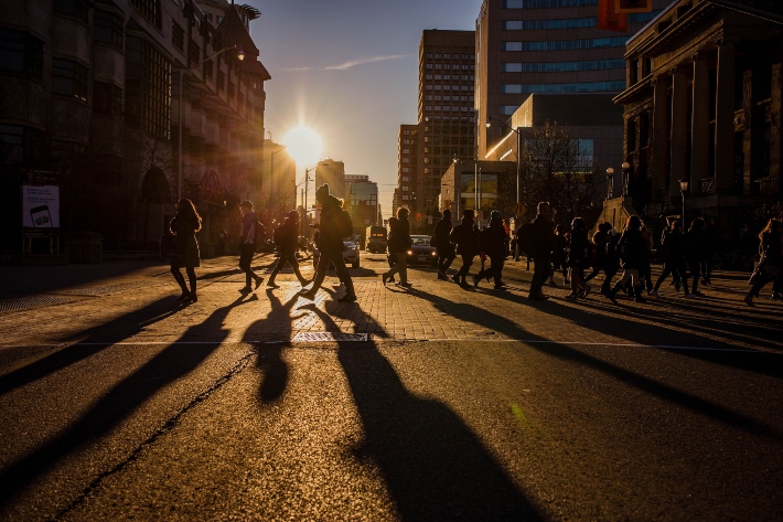 Students walking across street at sunset.