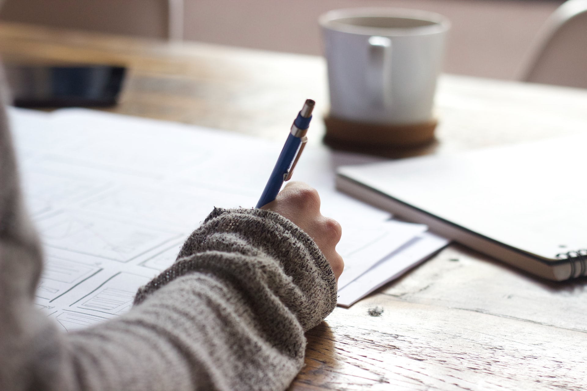 a hand writing in a notebook