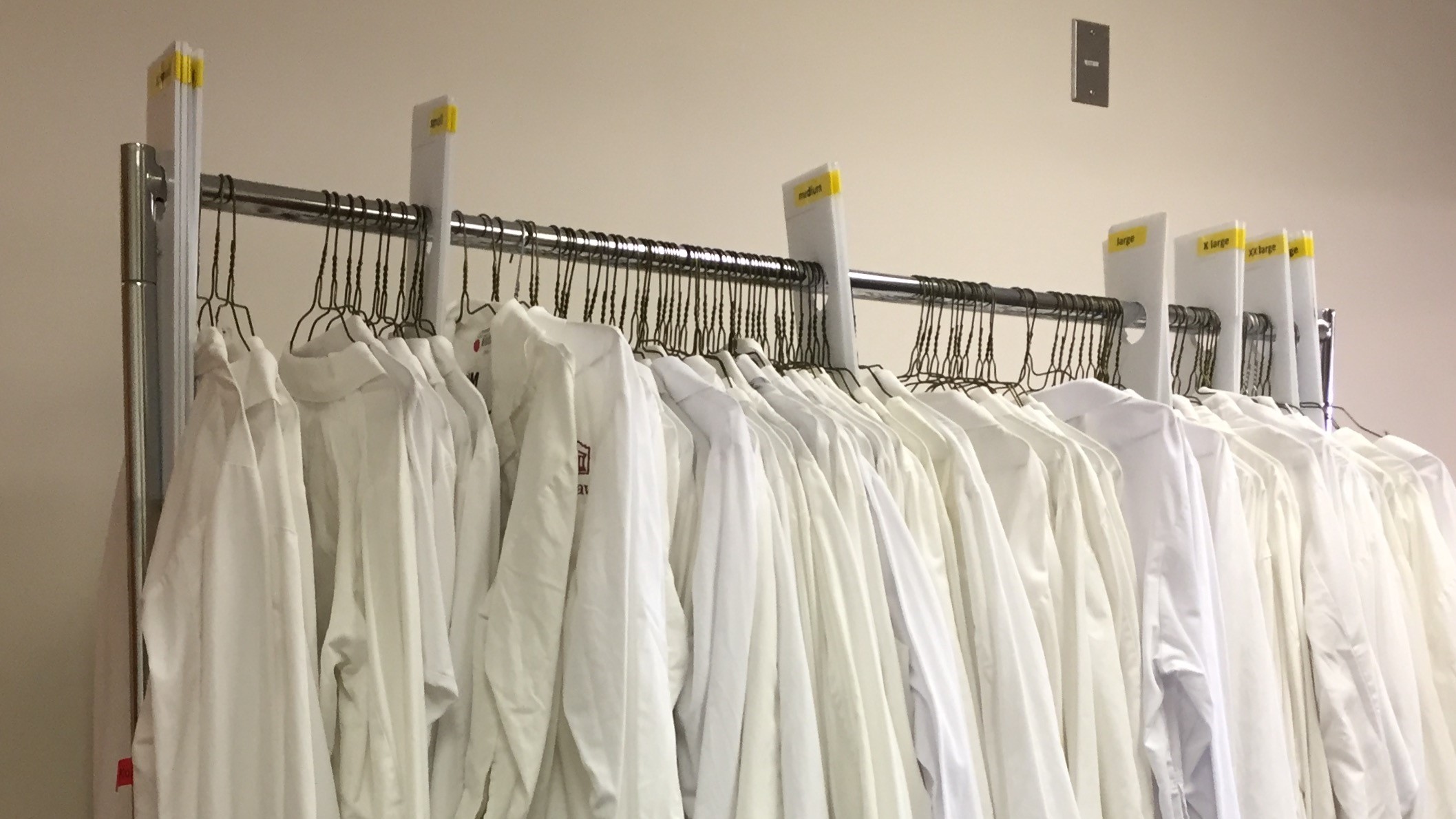 Lab coats hanging on rack.