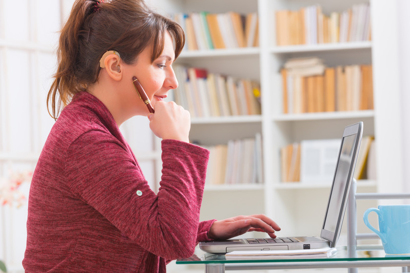 hearing impaired women sitting down looking at computer 