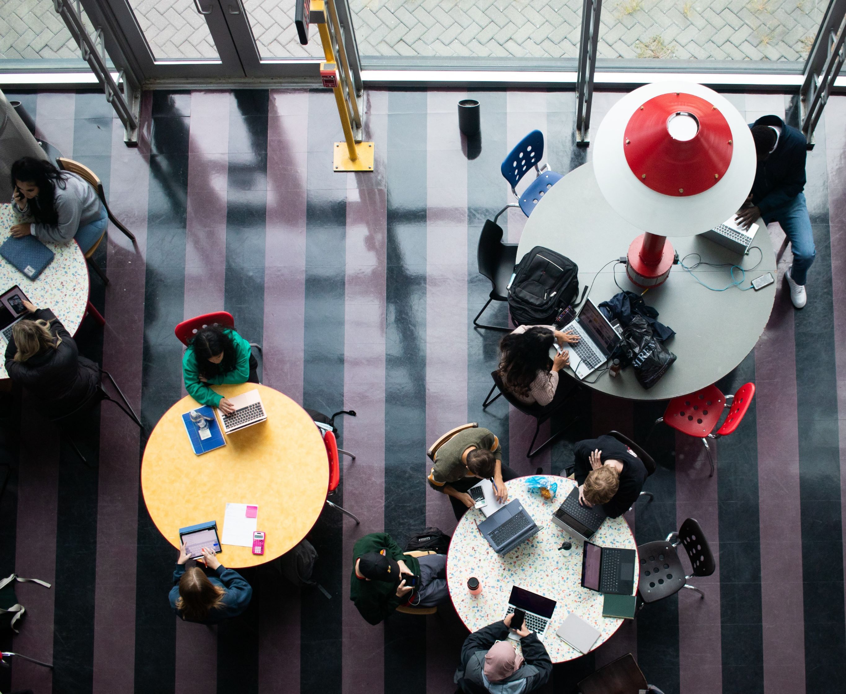 people sitting at round study tables, seen from above