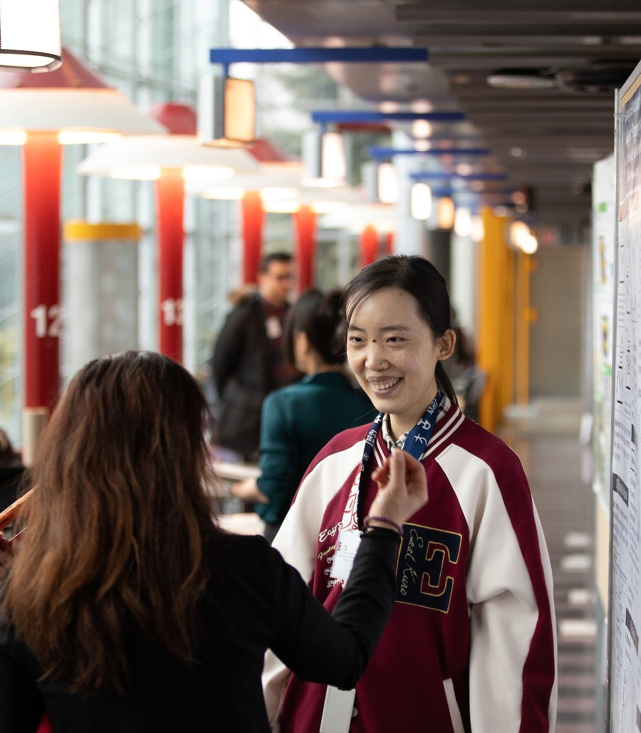 a student presents her project to a professor in a poster fair