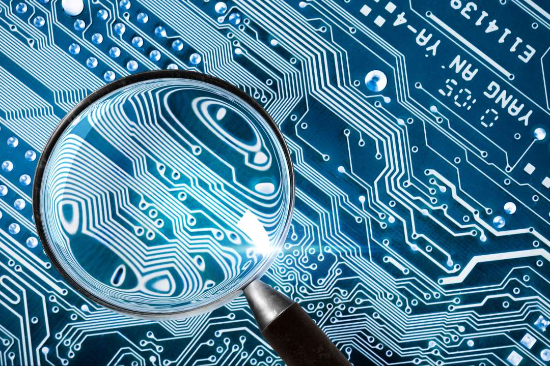 Magnifier upon a blue electronic circuit board 