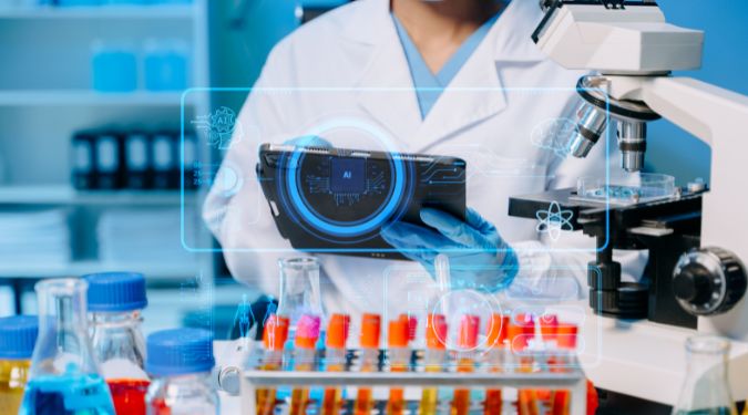 A scientist wearing a white lab coat and blue gloves in a laboratory setting holds a tablet displaying an "AI" graphic overlay