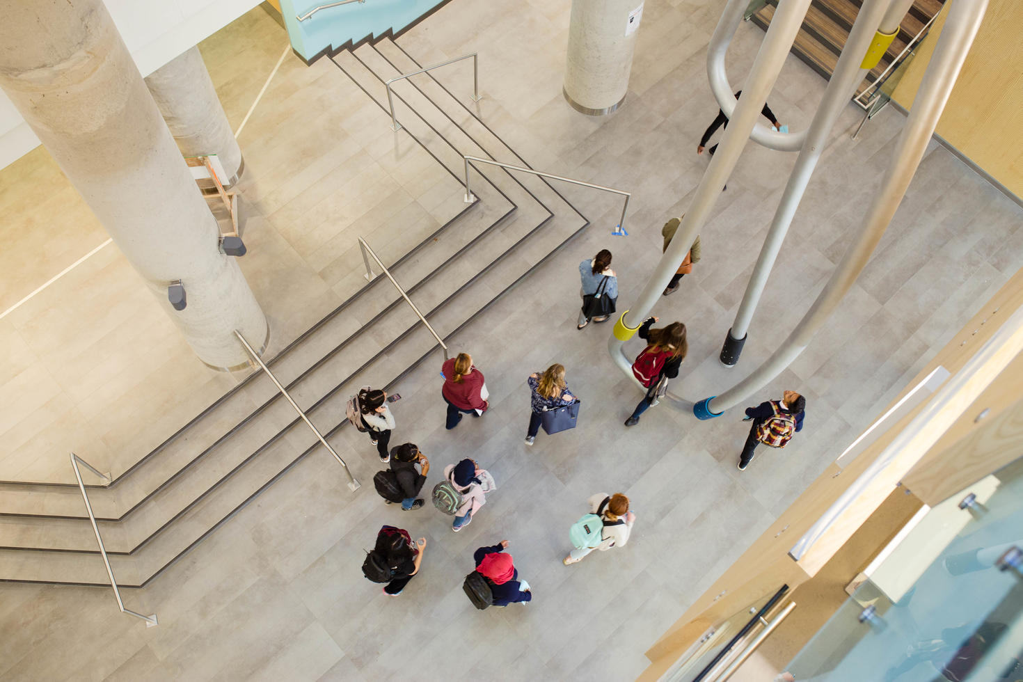Birds eye view of people walking through building.