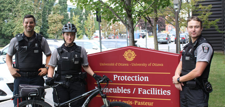 Employees of protection services standing in front of Protection sign.