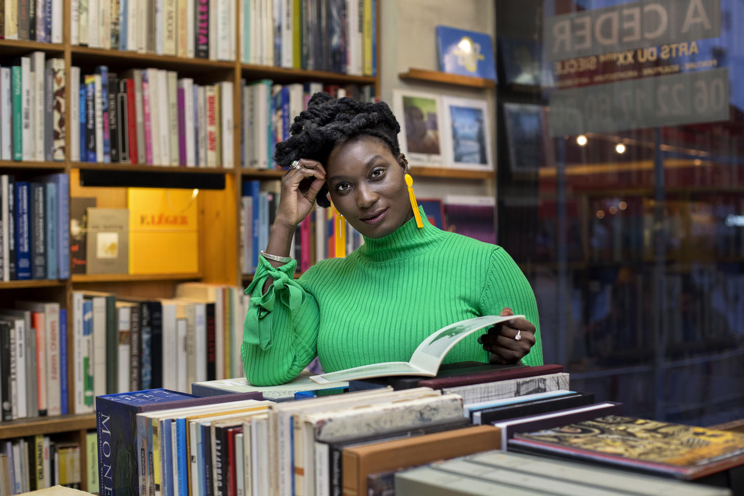 Person standing in library reading book.