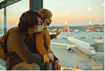 Father and son looking at planes taking off inside the airport.