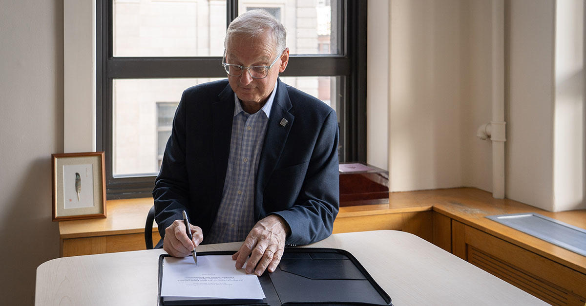 Le président Jacques Fremont signe la Charte de Scarborough dans son bureau.