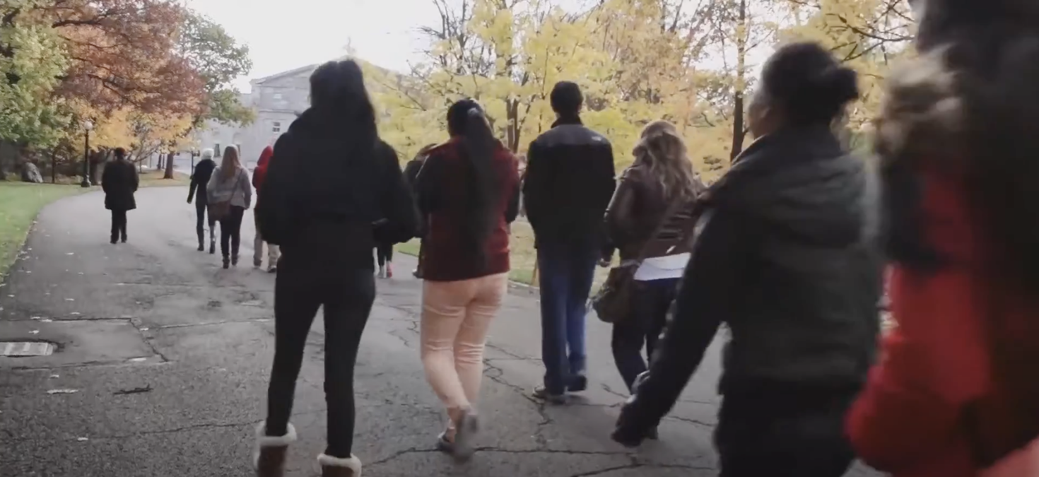 Video still of students walking through campus.