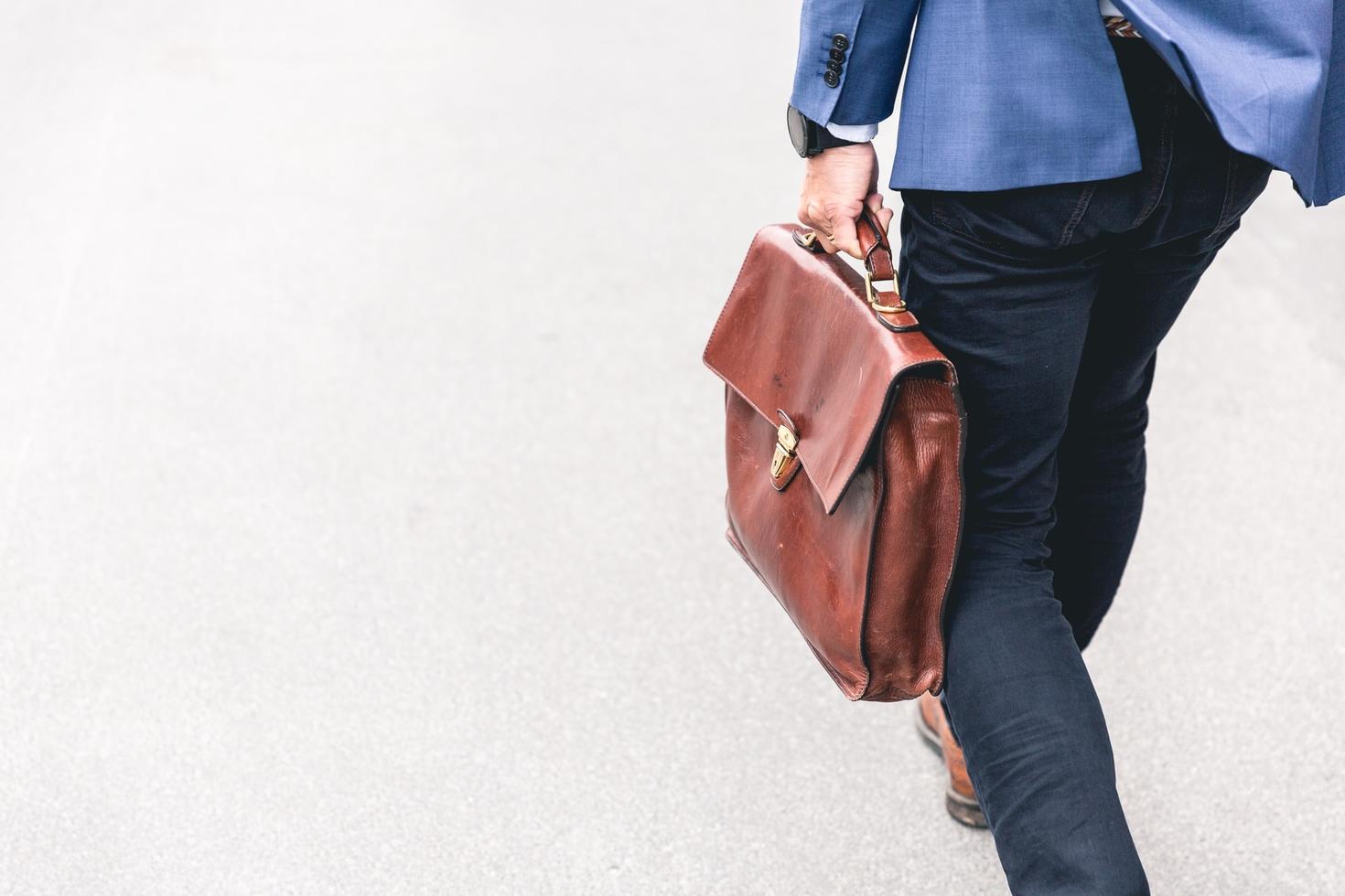 a person walking while holding a briefcase