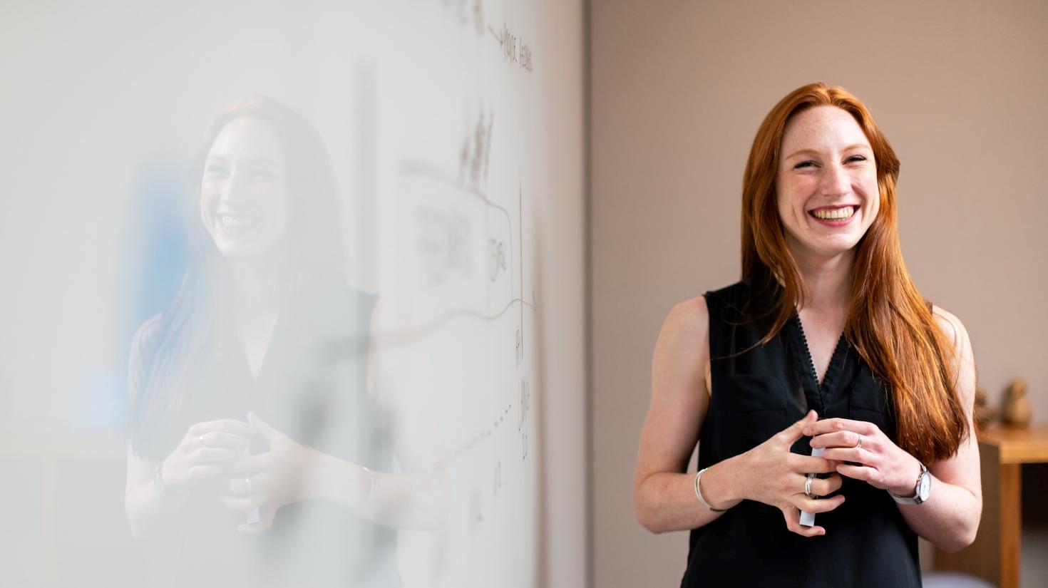 a professor smiling near her whiteboard