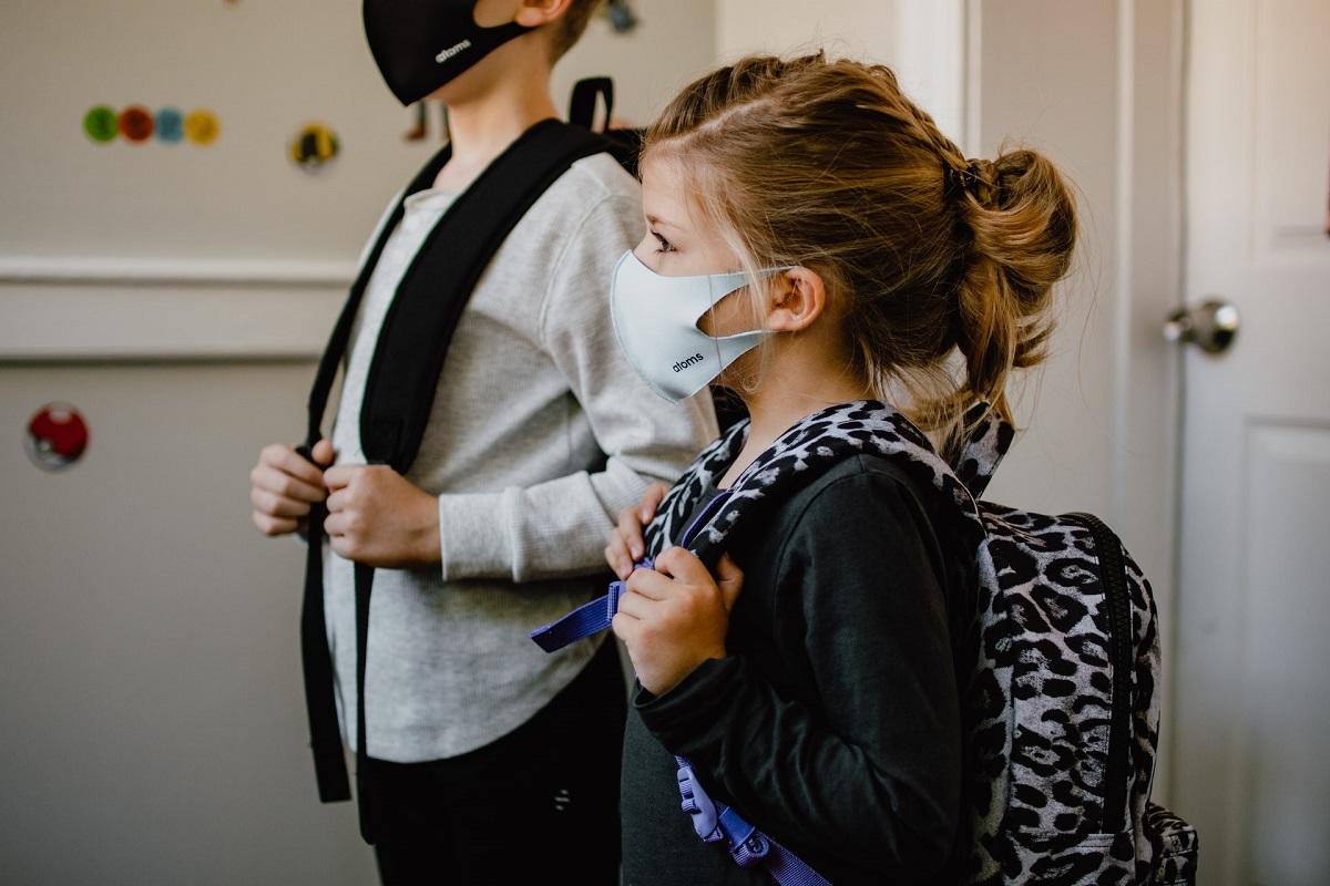 Young girl wearing mask and backpack ready for school