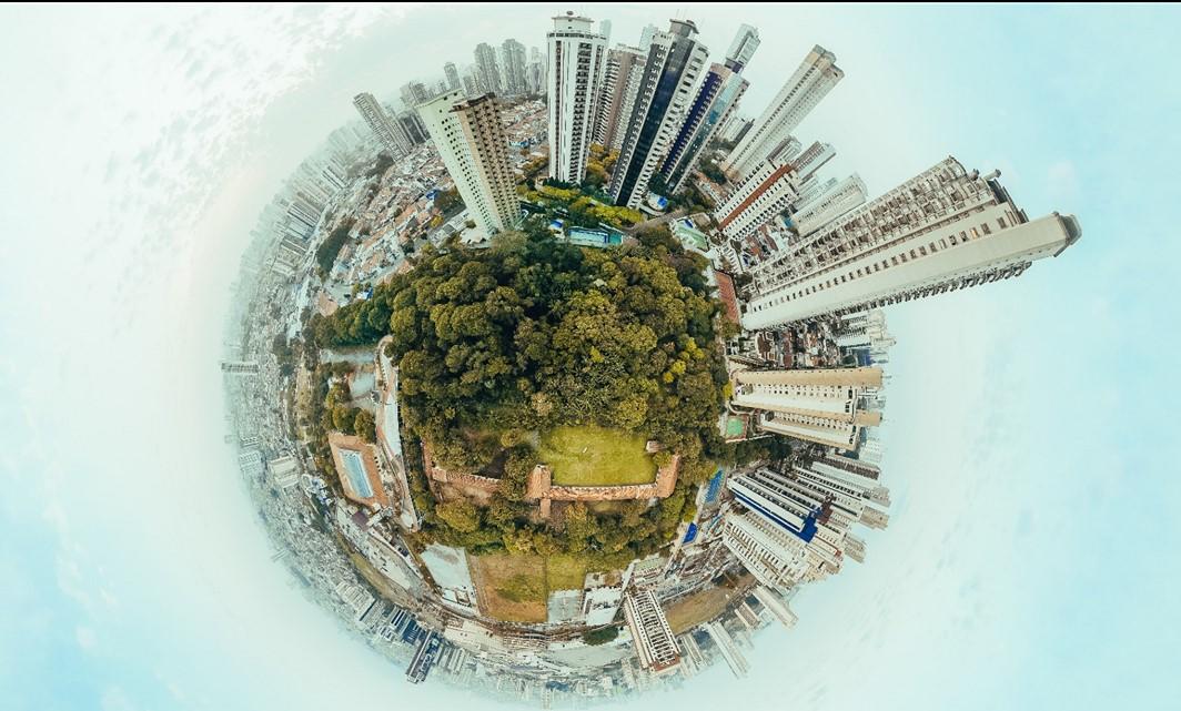 Planet earth covered with skyscrapers and a patch of green space