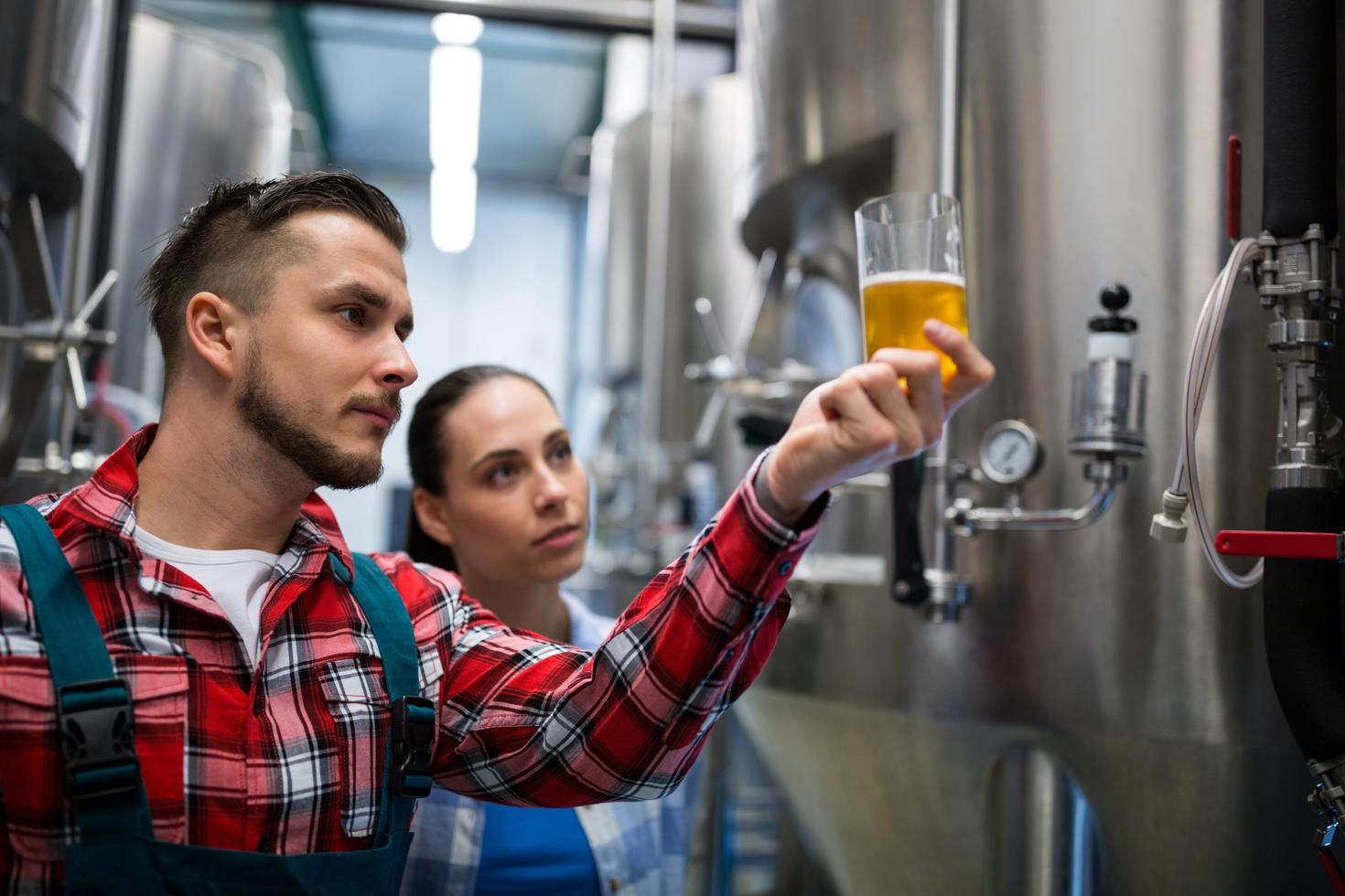Two people studying a beer.