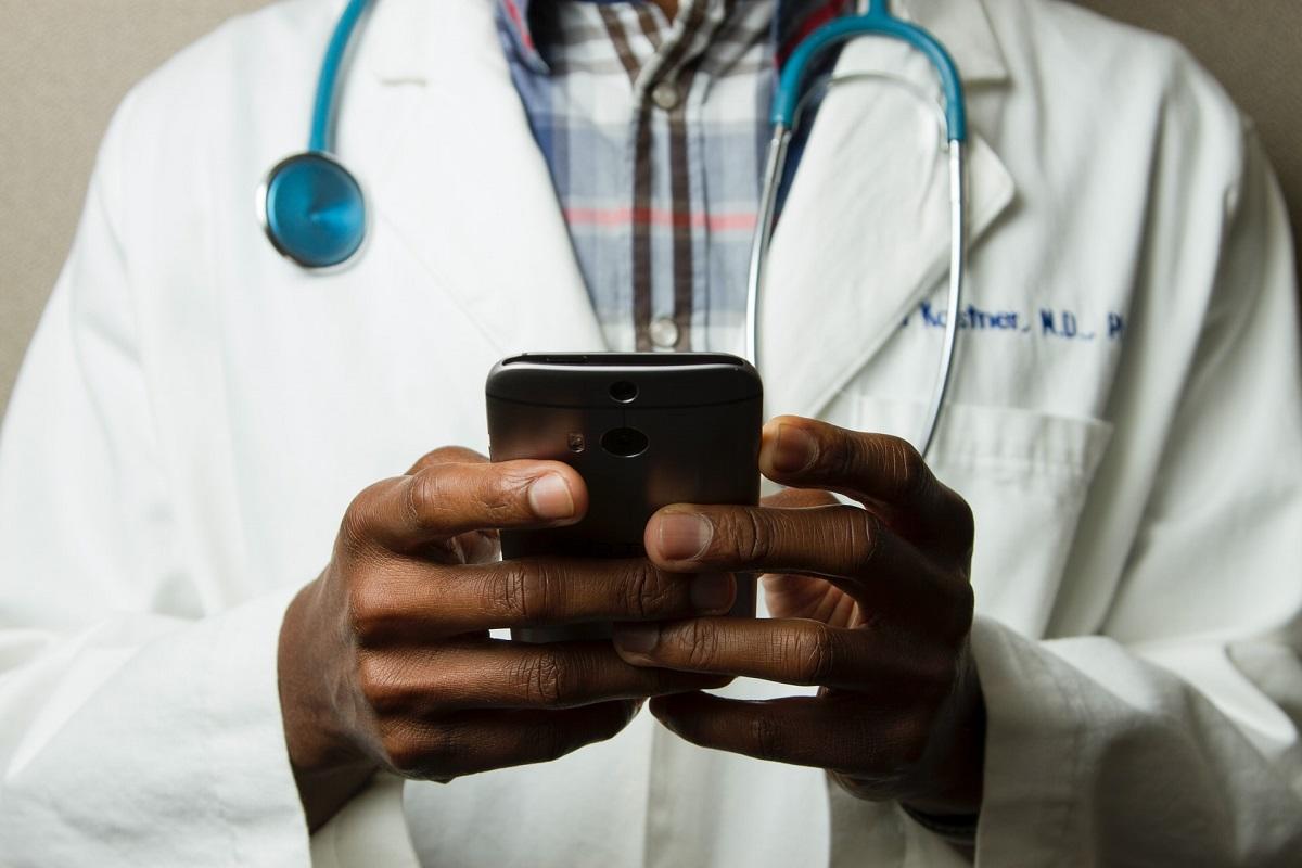 Close-up of physician's hands using smartphone