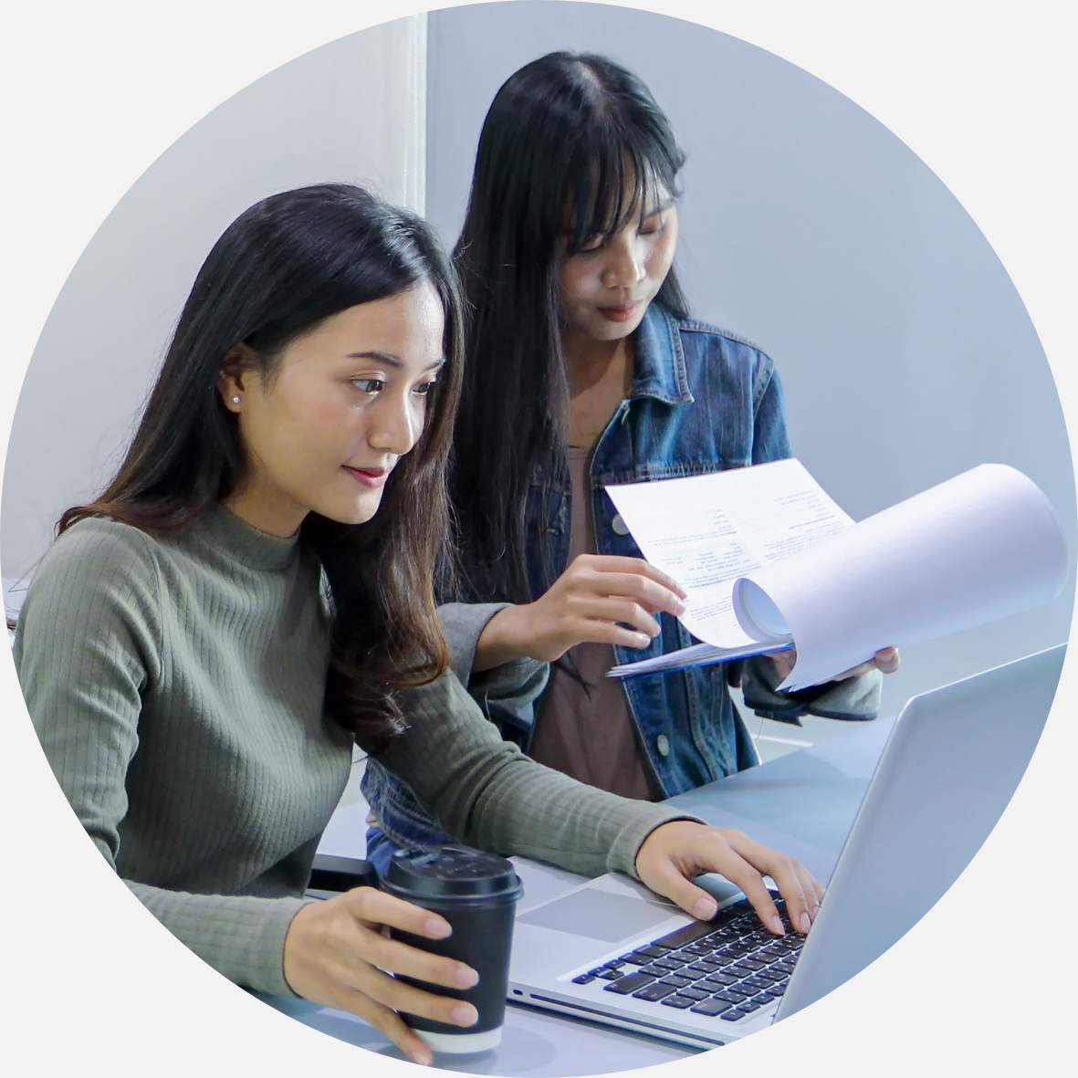 Students researching with a computer and notes