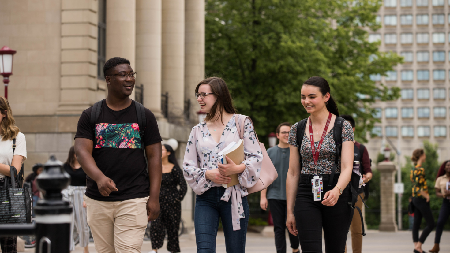 Photo group of 3 students walking on campus