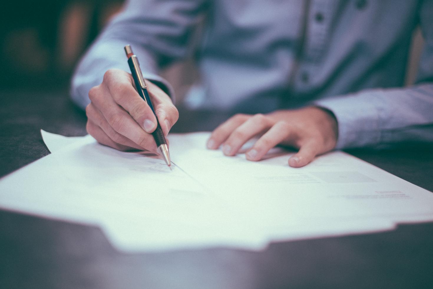 A person writting on a paper.