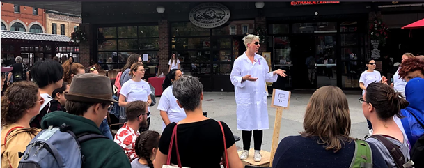 Blond woman on soapbox speaking to crowd in Byward market