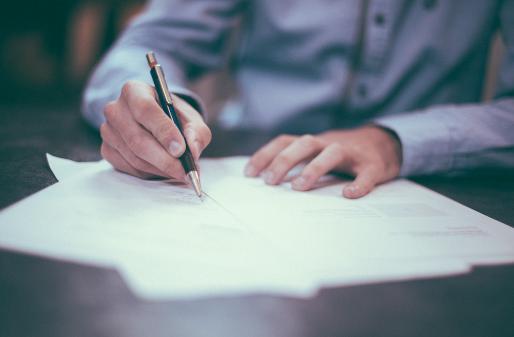 Person writing on pieces of paper.