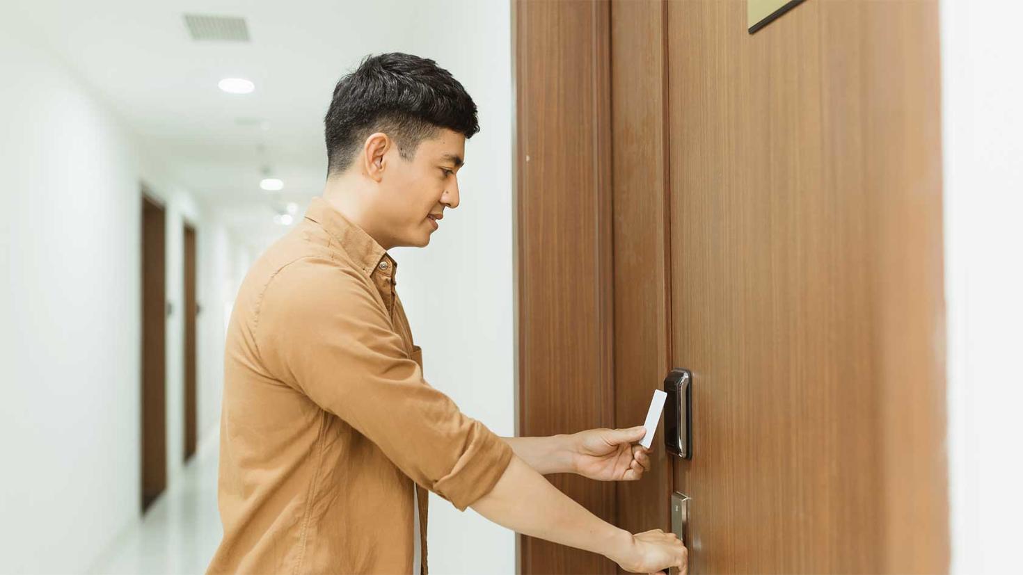 A student using their card to unlock their room door.
