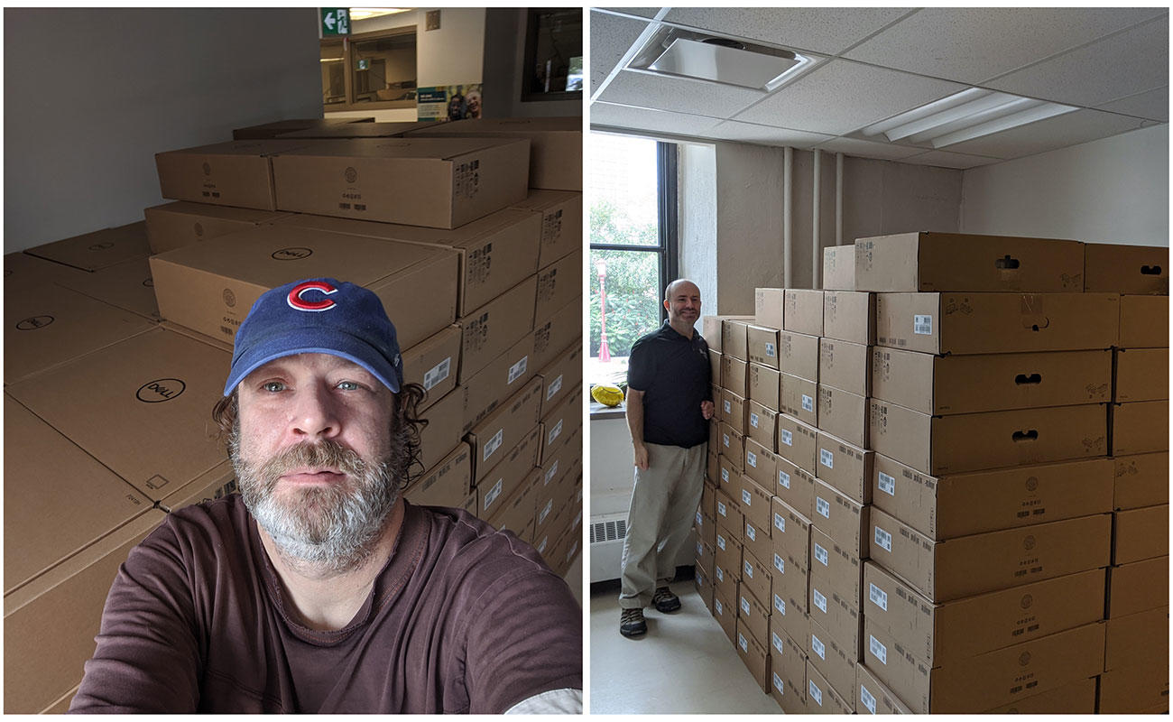 Staff members standing beside a pile of cardboard boxes.