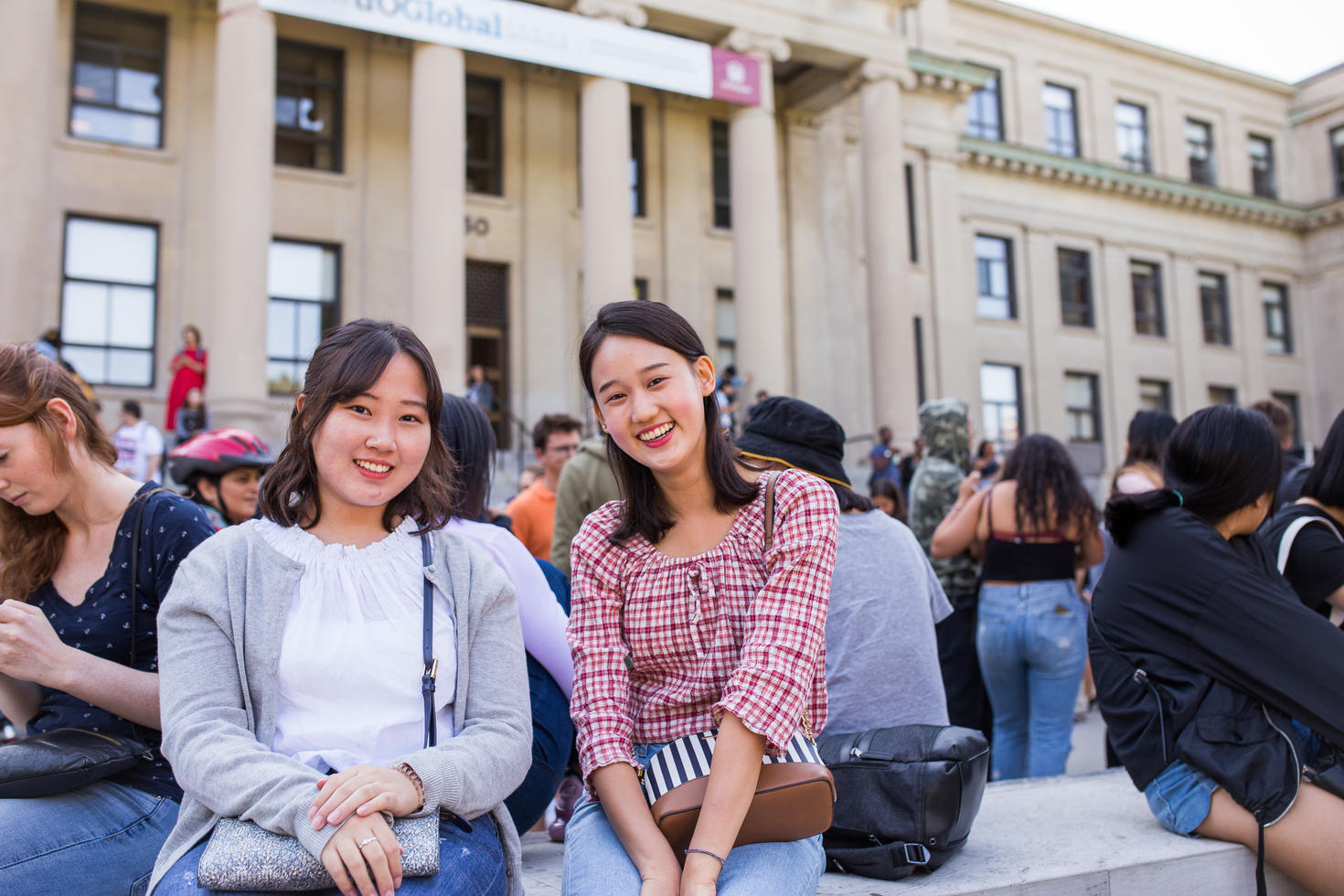 Two students in front of building on campus