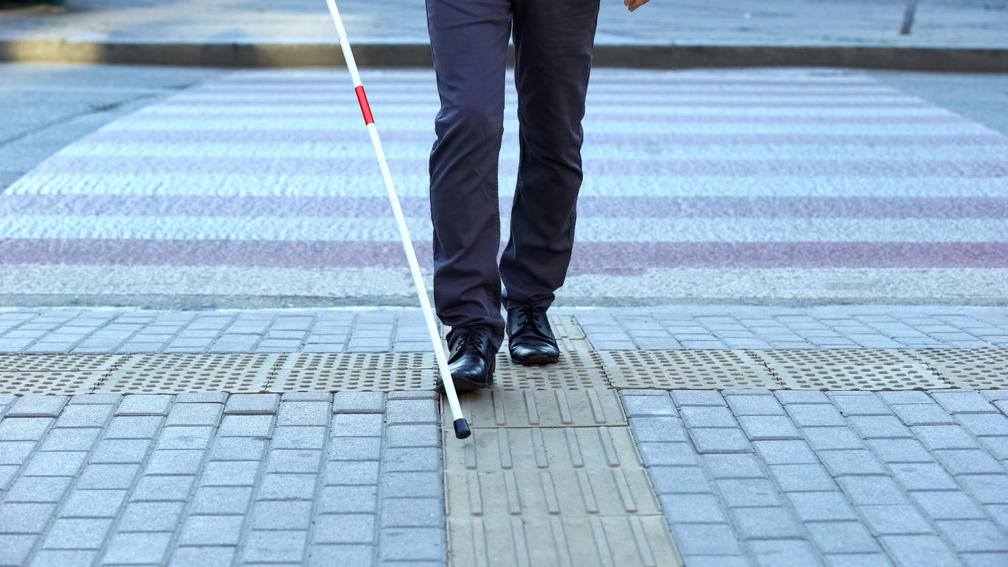 A visually impaired person crossing the road