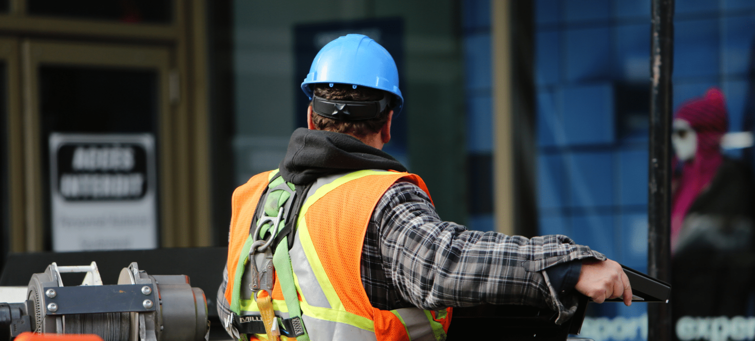 A worker wearing a harness and safety gear