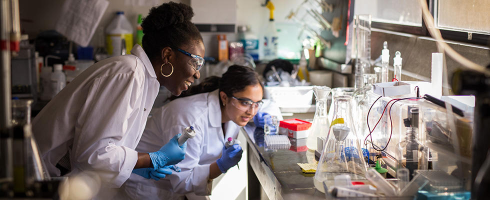 Two chemistry students looking at experiment