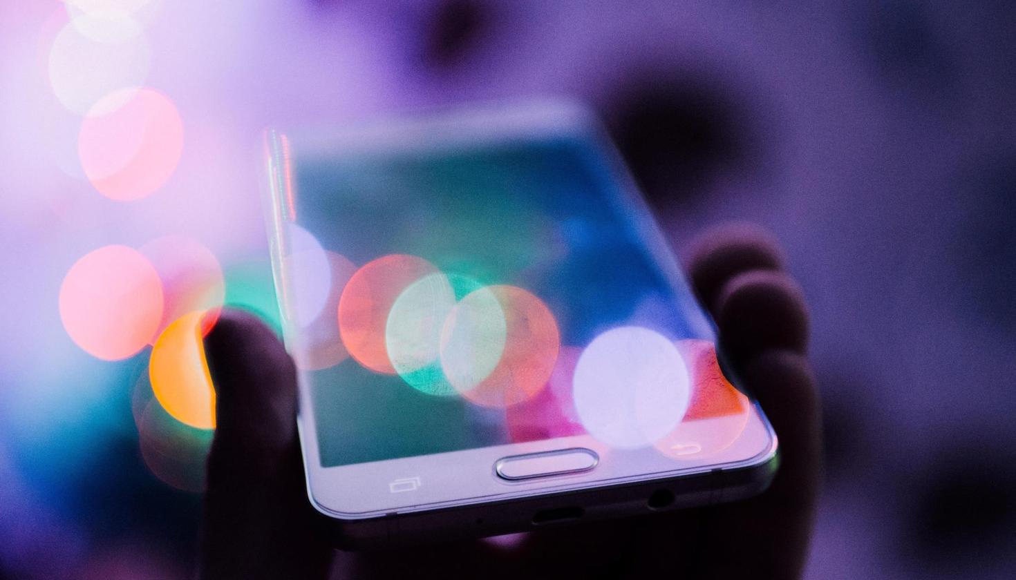 hand holding a purple hued portable phone