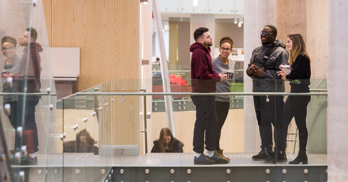 A group of students standing, talking to each other.