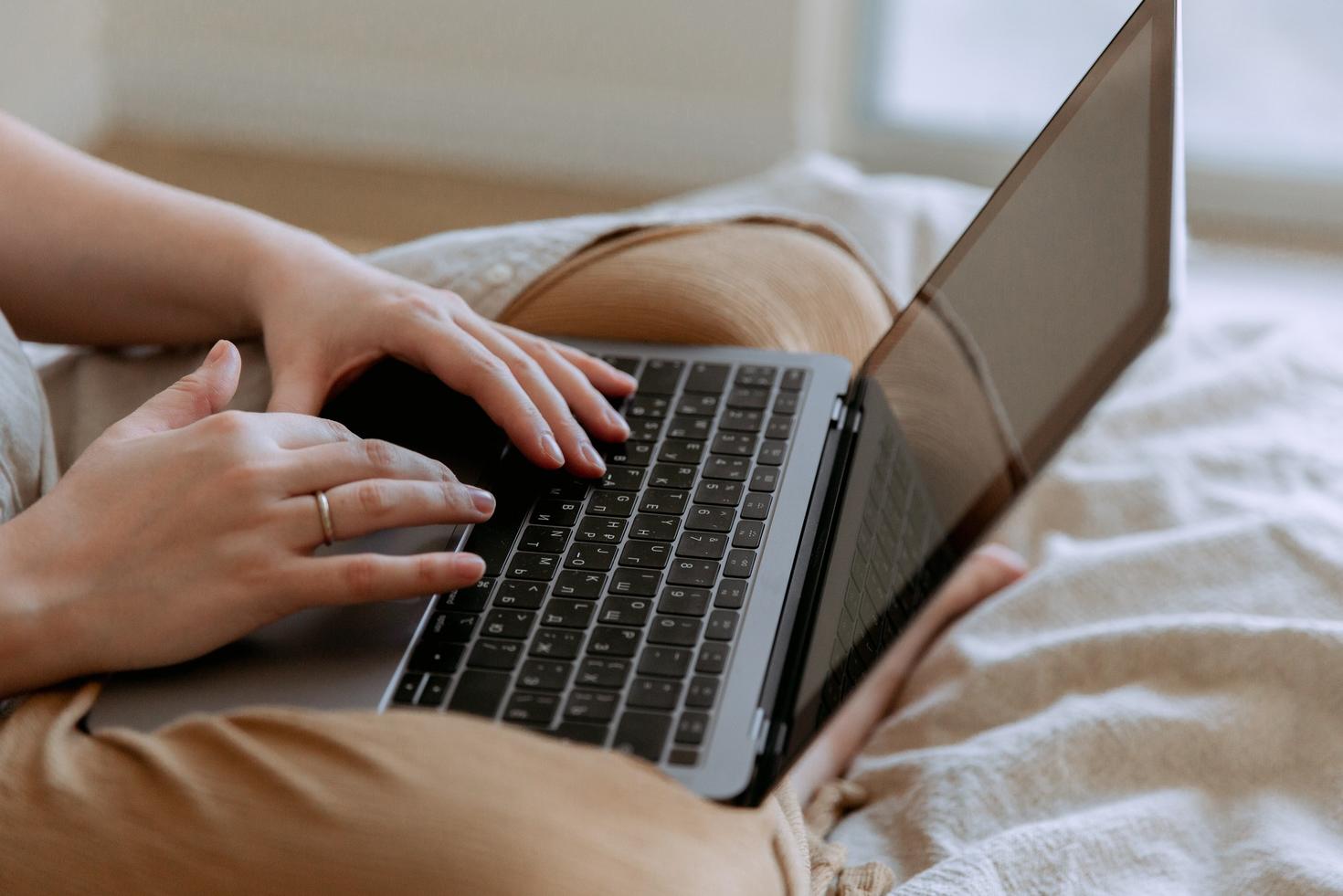 Hands typing on a laptop