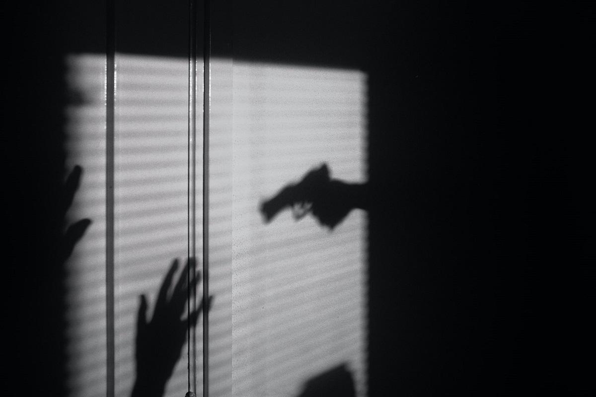 Shadow showing gun pointed with hands up