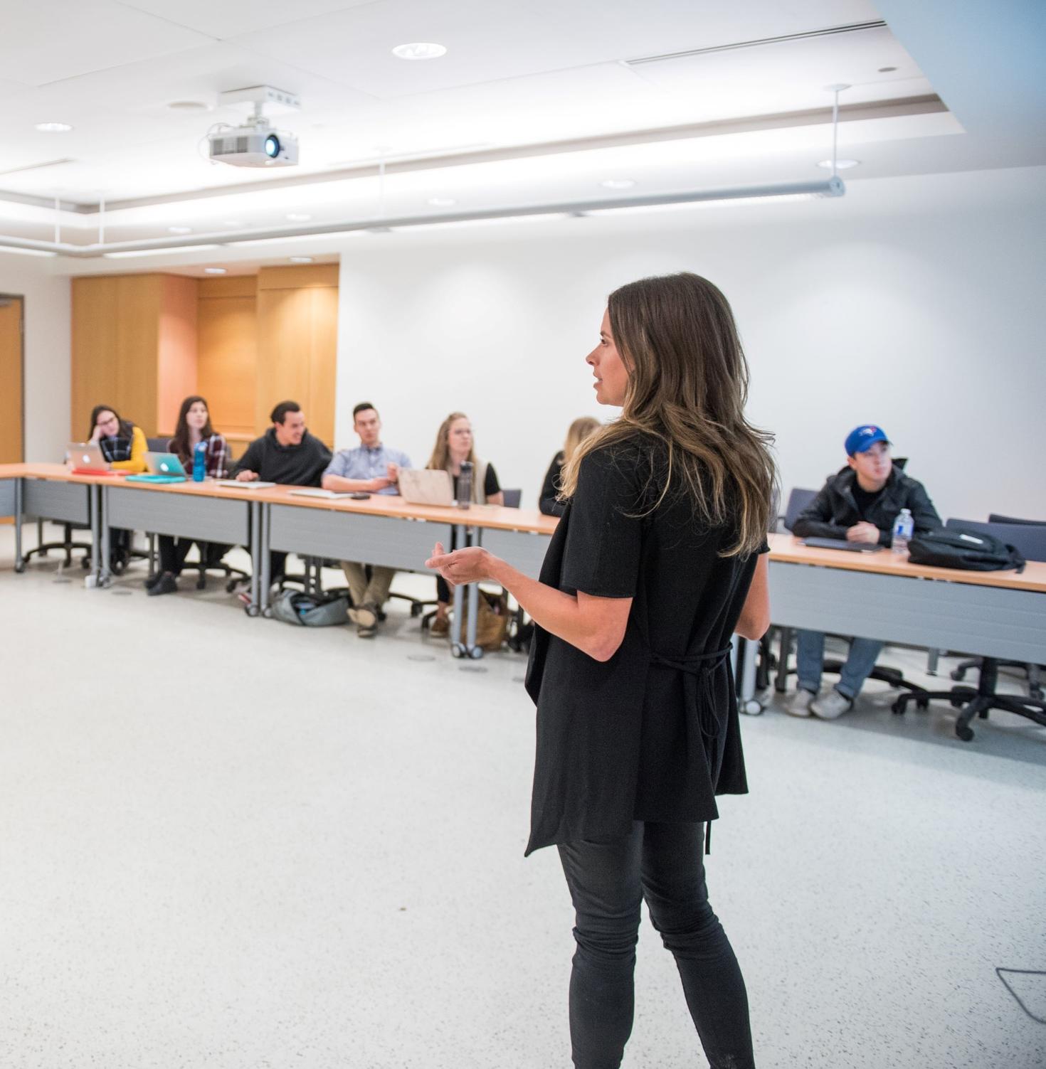 person giving a presentation in front of students in a classroom