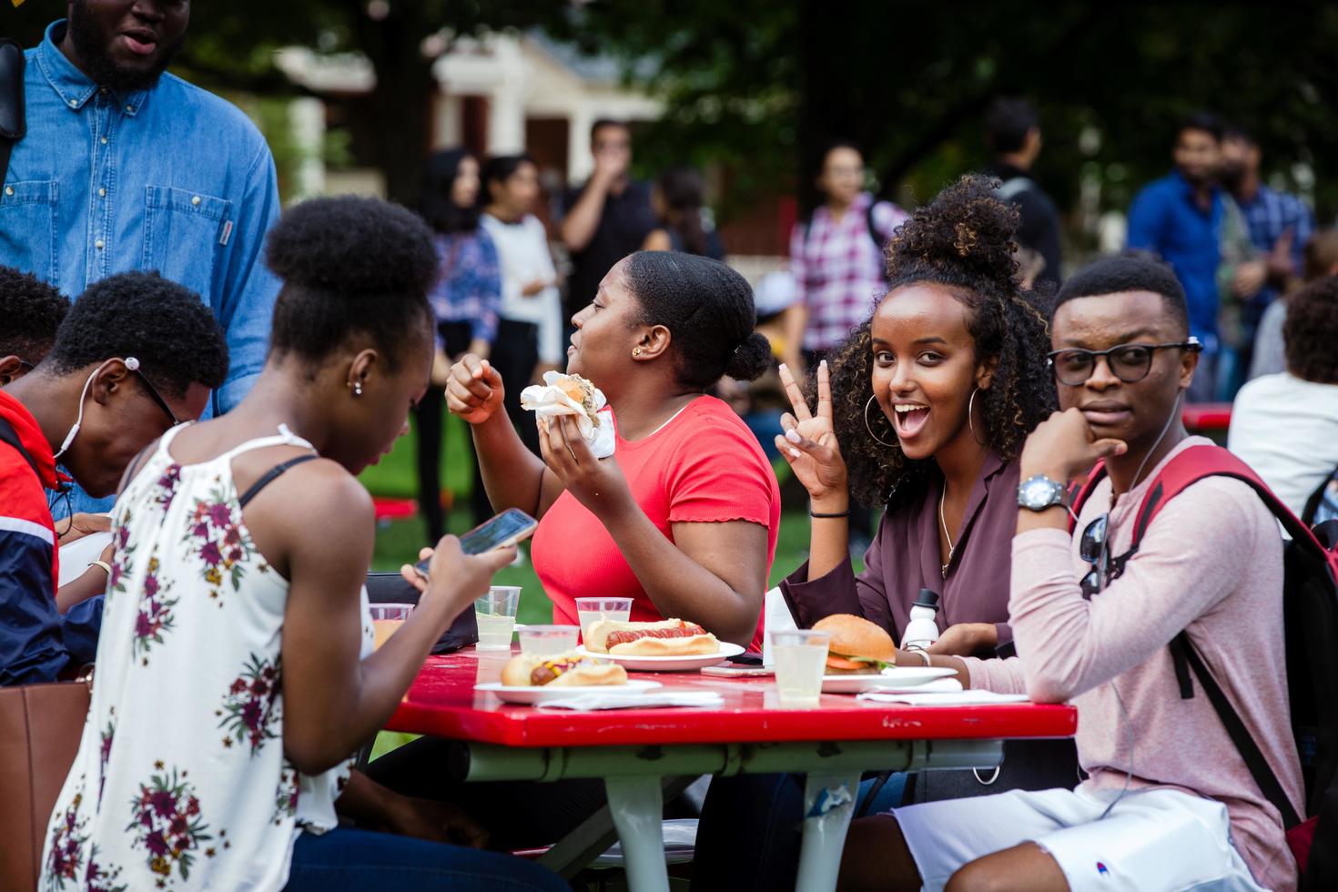 Group of students eating at  picnic table on campus