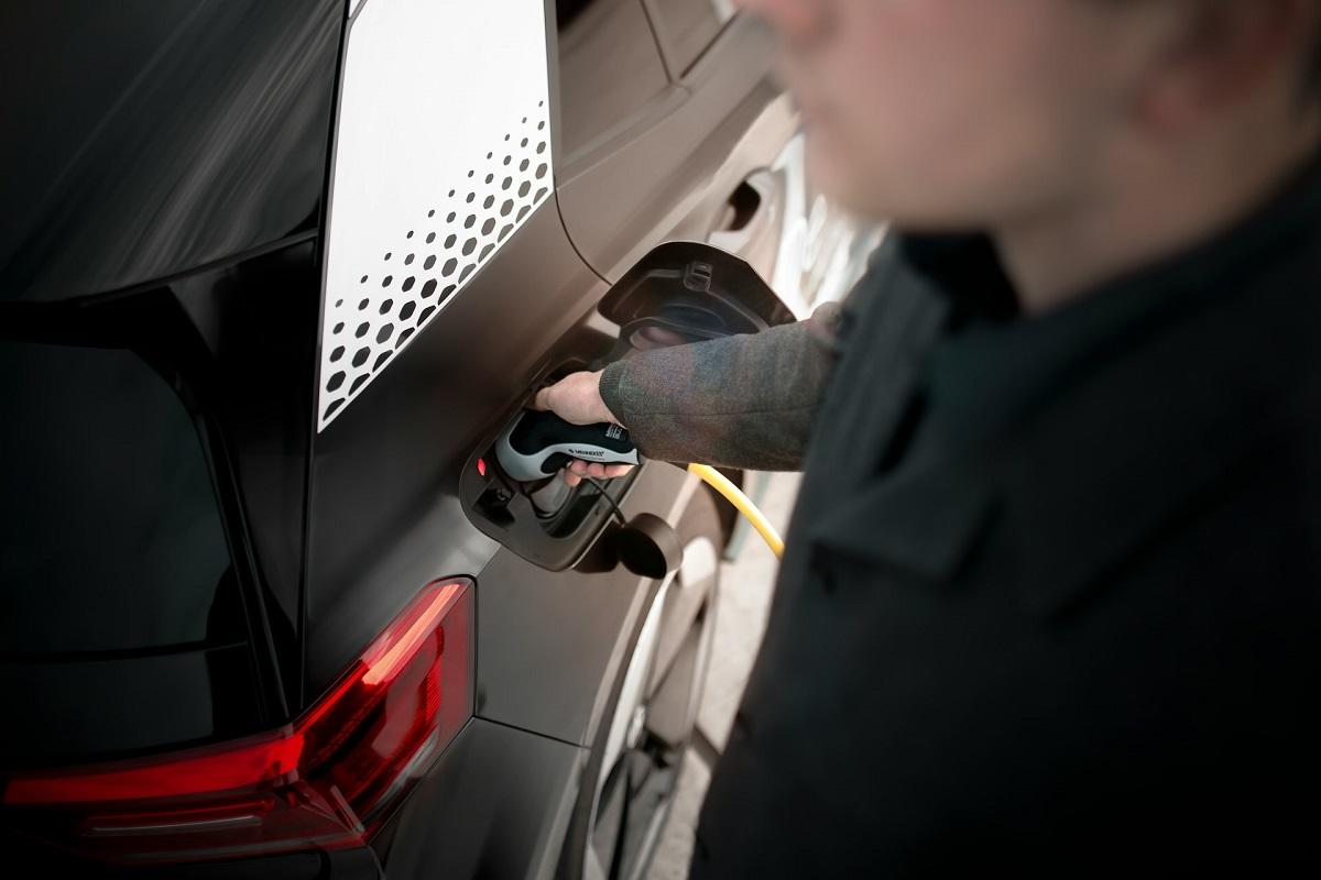 Man charging electric vehicle
