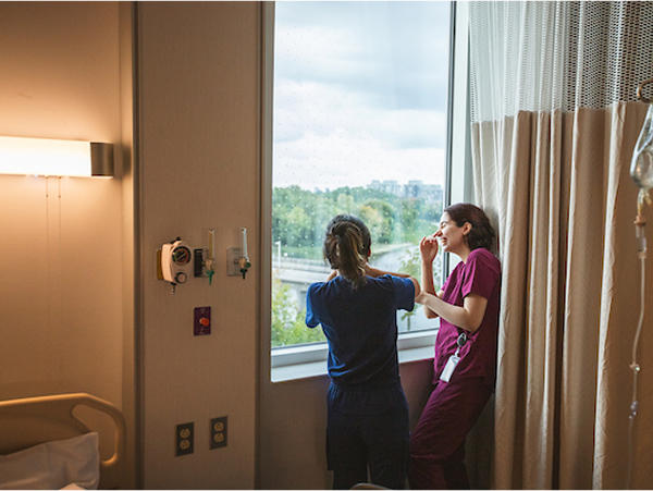 Two med students looking out a window