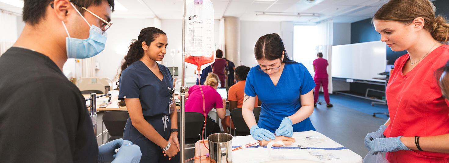 Faculty of medicine students practicing their skills on a dummy hand