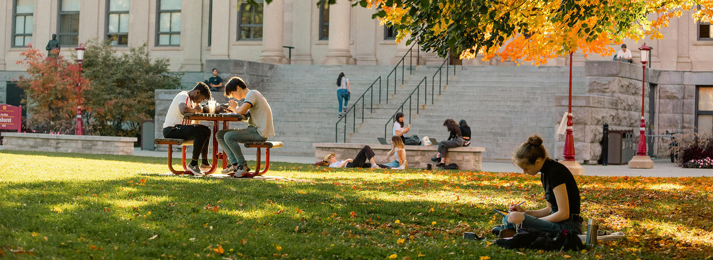 Students studying in front of Tabaret Hall