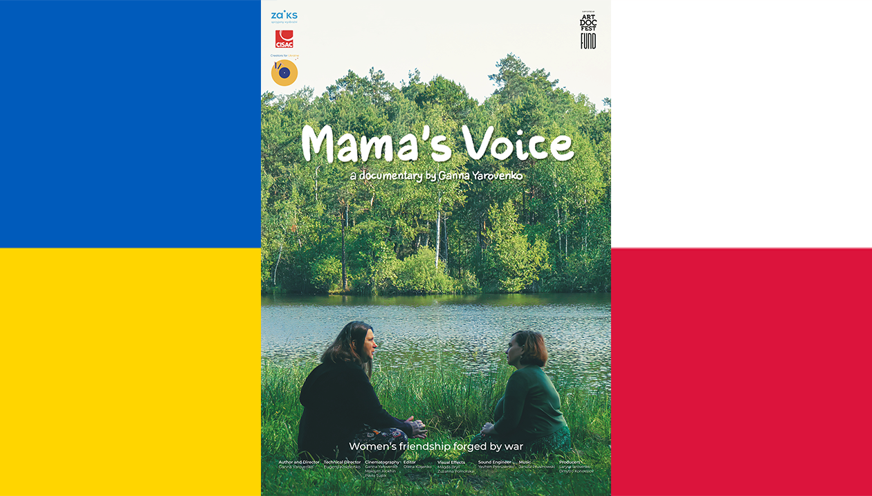 Two women sitting on grass by a river with the flags of Ukraine and Poland in the background