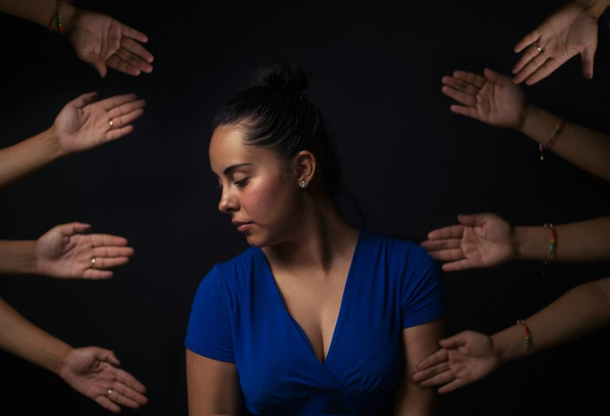 Woman amid flailing hands all around her