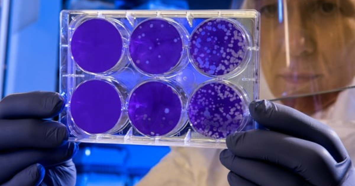 A scientist holding containers with enzymes