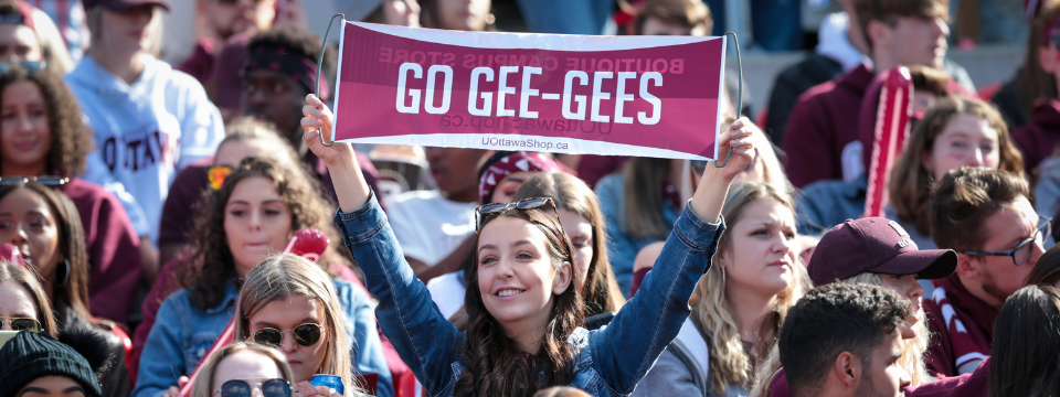 Fan holds up a sign reading 'Go Gee-Gees' at Panda Game