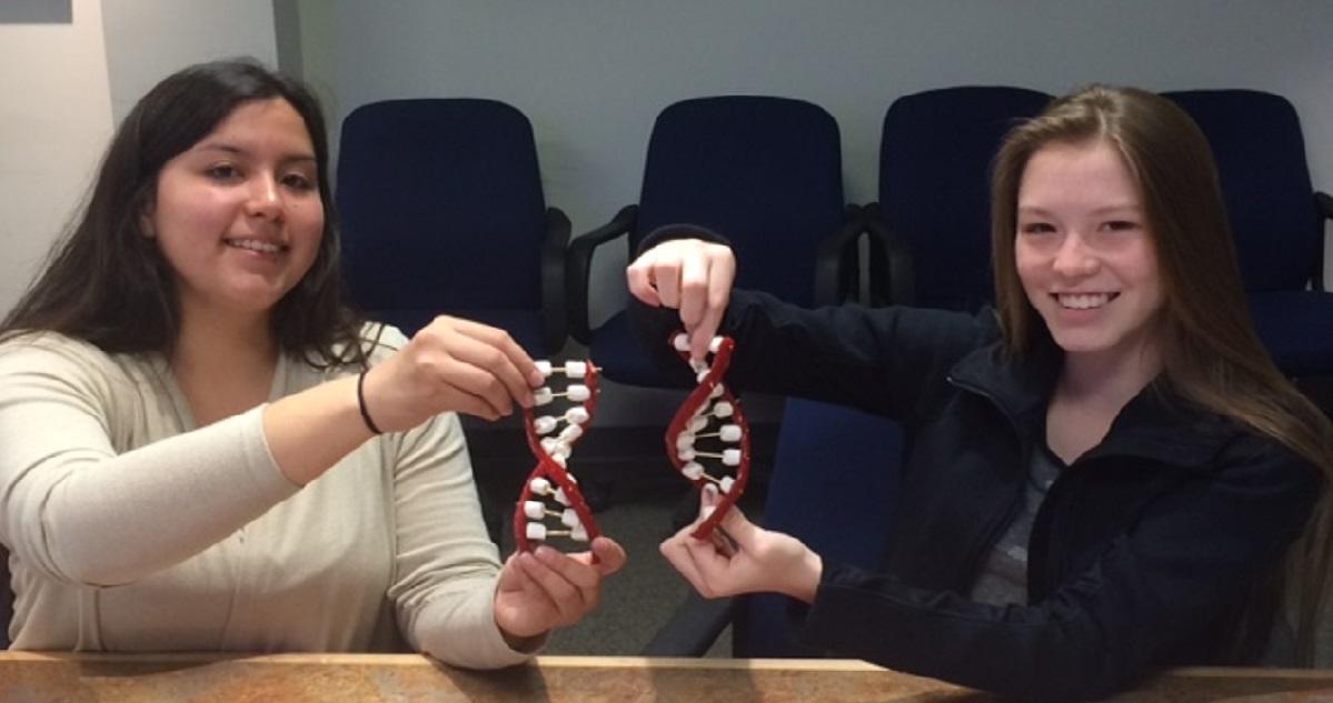 Two young girls experience a hands-on science activity.