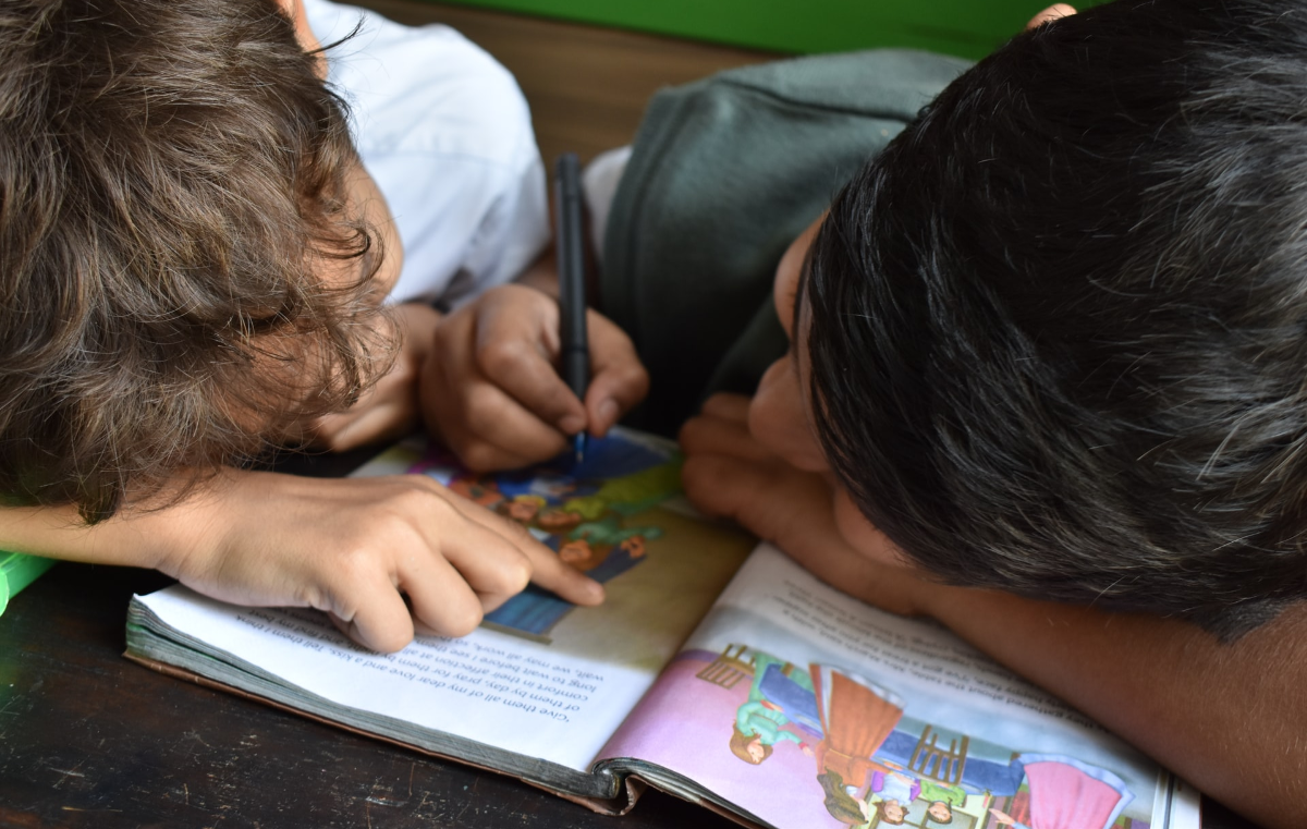 Two kids reading a book