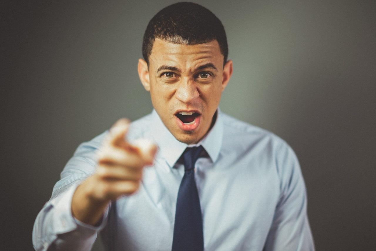 Man pointing finger at camera, appearing aggressive
