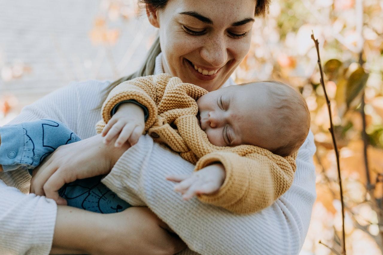 Woman cradling her baby in outdoor setting